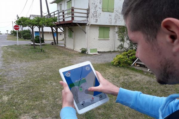 une personne qui tient une tablette et qui regarde une carte digitale