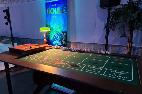 table de casino de la boule. En arrière plan un roll up avec écrit boule. Sur la table se trouve des jetons et la boule