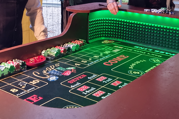 une table de craps avec des leds vertes autour et des jetons disposés sur le bord