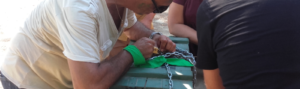 une personne qui tente d'ouvrir un cadenas qui bloque un coffre vert