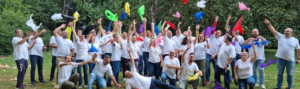 un groupe de personnes en t-shirt blanc jettent en l'air des foulards de couleurs différentes
