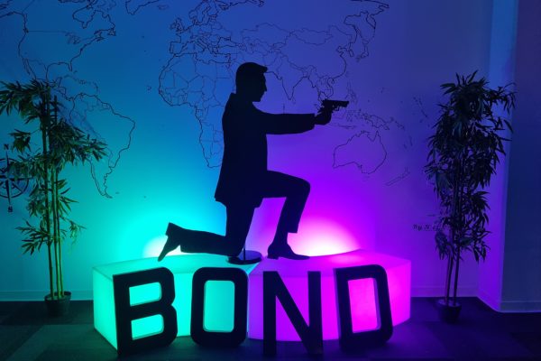 silhouette james bond sur un banc lumineux avec écrit "bond" en grosse lettre